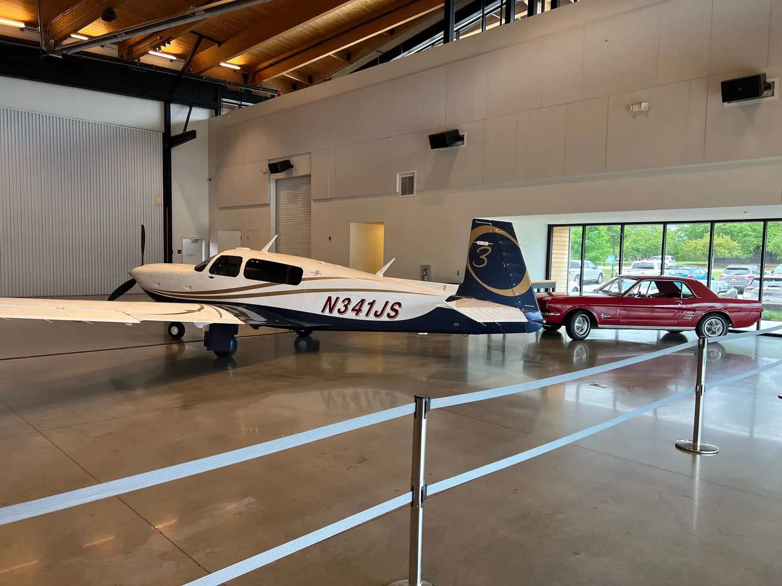 Mooney aircraft alongside a classic Mustang inside the Alpha Company Aviation Sanford Florida hangar