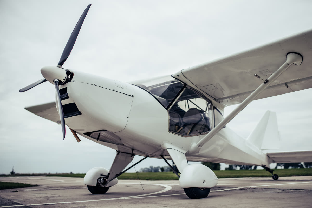 White single-engine general aviation airplane parked on an airport ramp in the Southeast
